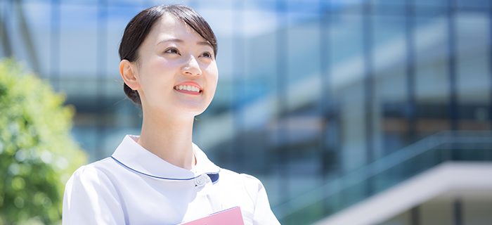 窓辺で微笑む女性看護師